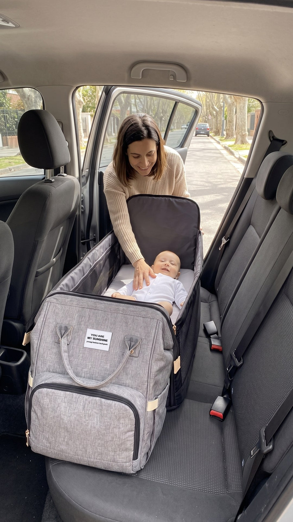 La abre en el asiento del auto y lo cambia