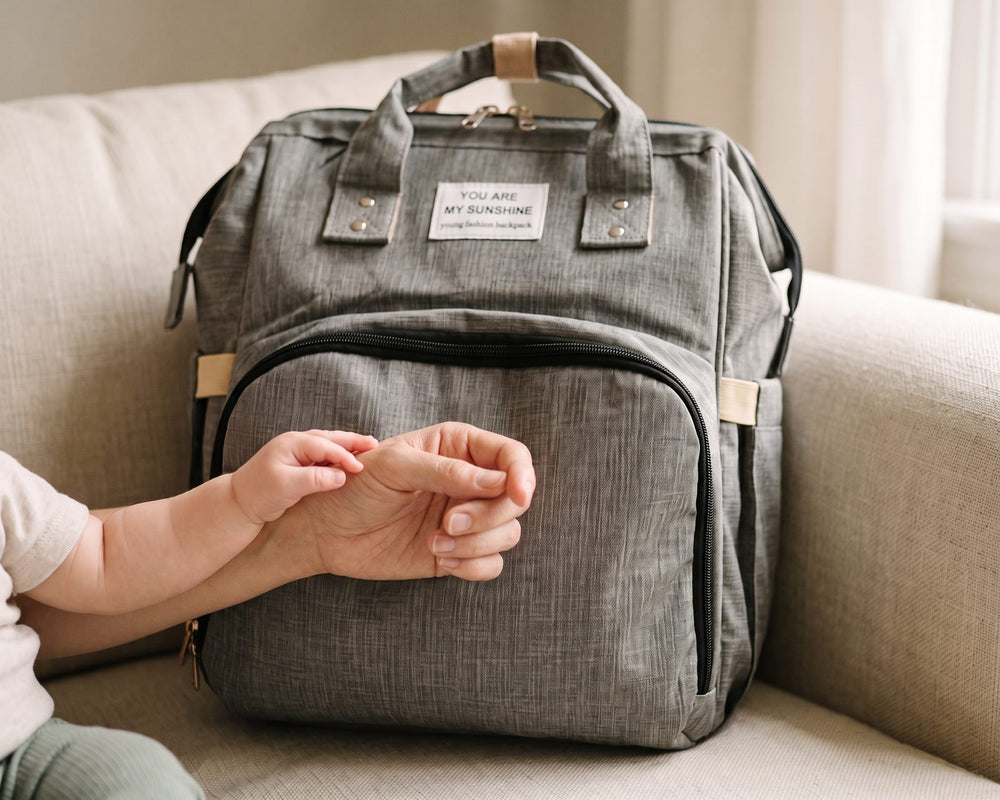 Manos de mamá y del bebé sobre la mochila