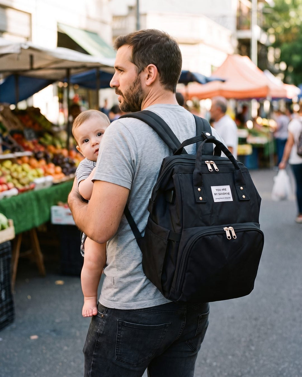 Papá con la mochila a la espalda y el bebé a upa
